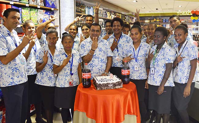 Prouds PNG manager Kiran Rathod is flanked by staff members to celebrate the second anniversary at Jackson's International Airport