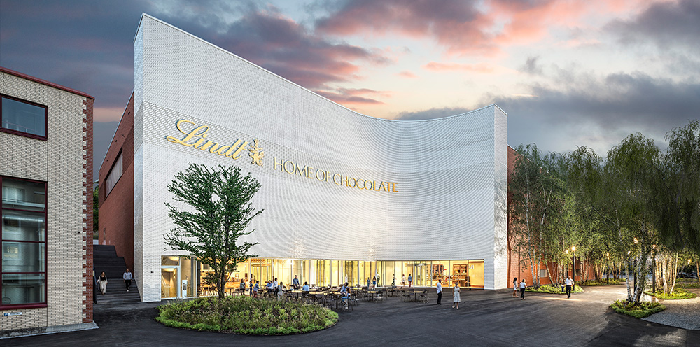 Lindt_Home_of_Chocolate_rendering of the exterior July 2020 – TRBusiness Lindt – TRBusiness's new Home of Chocolate will feature an interactive exhibition, a research facility, a spectacular nine-metre high chocolate fountain, a ‘Chocolate Heaven’ tasting room, the first Lindt Café, a Chocolateria for chocolate courses and the largest Lindt Chocolate boutique in the world.